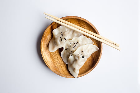 three dumplings on brown wooden plate thumbnail