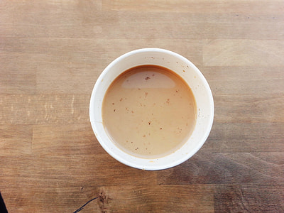 filled white disposable cup on brown table thumbnail