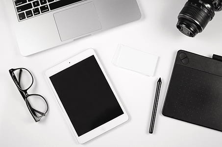 flat lay photography of white iPad, black framed eyeglasses, and ballpoint pen thumbnail