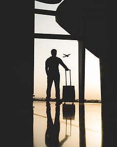 silhouette of man looking at the window of the airport thumbnail