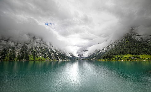 calm body of water in front of mountain thumbnail