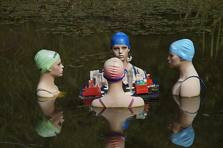 four mannequins surrounding table floating on water thumbnail