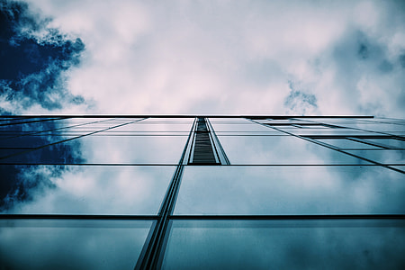 low-angle photography of high-rise building under white clouds thumbnail