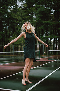 woman in teal sleeveless dress on tennis court thumbnail