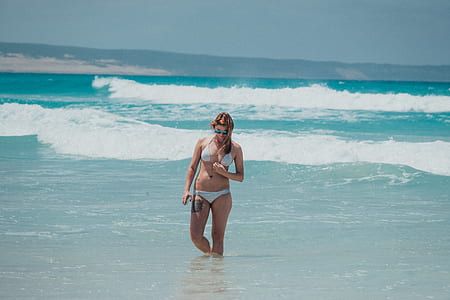 woman in white bikini standing in beach thumbnail