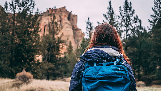 woman wearing blue backpack in front of mountain thumbnail