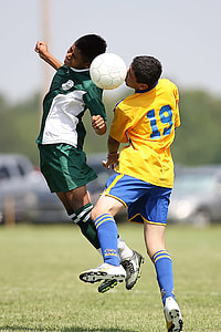 two soccer players heading a soccer ball in field thumbnail