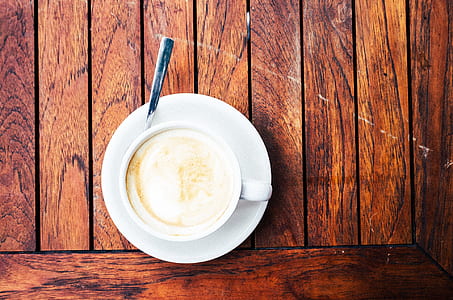 top view photography of white mug on saucer with teaspoon thumbnail