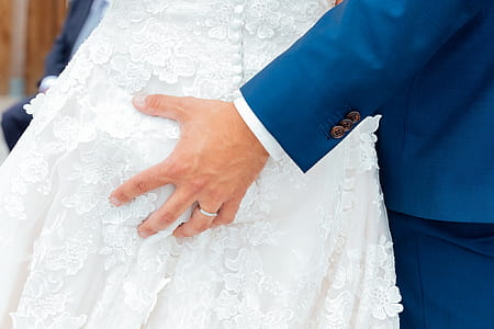man wearing blue blazer holding woman wearing white bridal gown thumbnail