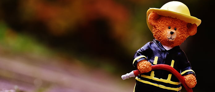 selective focus photography of brown ceramic fireman bear figurine thumbnail