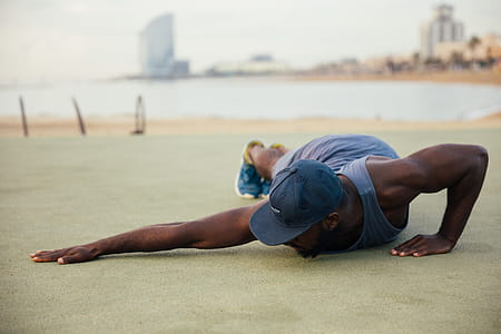 A young African man wearing casuals stretching outdoors thumbnail