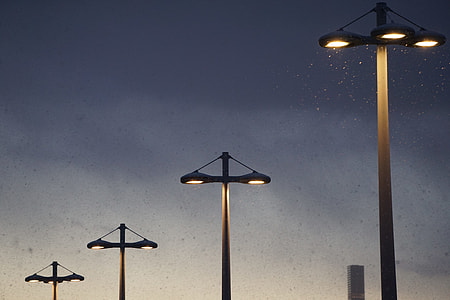 four lighted street lights at night thumbnail