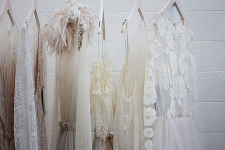 hanged beige and white dresses near white wall thumbnail