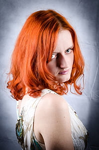 woman in white and teal floral sleeveless top posing for a photo thumbnail