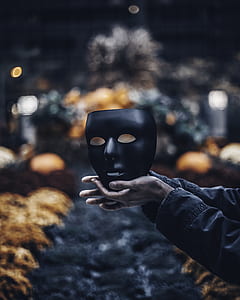person holding black mask thumbnail