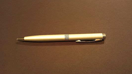 beige click pen on brown surface thumbnail