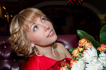 woman wearing red one-shoulder tops holding white and orange petaled flower bouquet thumbnail