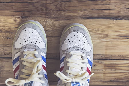 white-red-and-blue adidas sneakers on wooden surface thumbnail