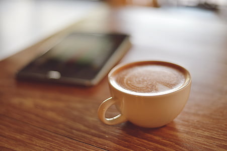 beige cup on brown wooden table thumbnail
