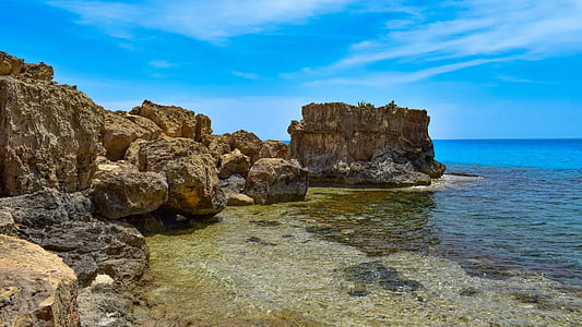 rock formation in front of body of water thumbnail
