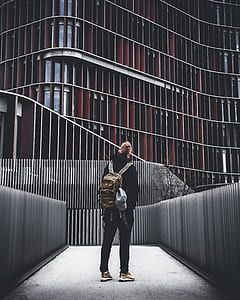 man wearing backpack looking an building thumbnail