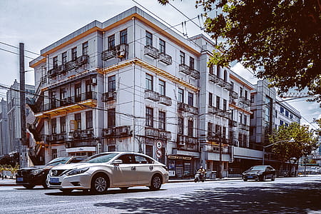 Vehicles On Road Near White Building thumbnail