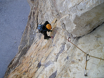 man climbing on brown mountain at daytime thumbnail
