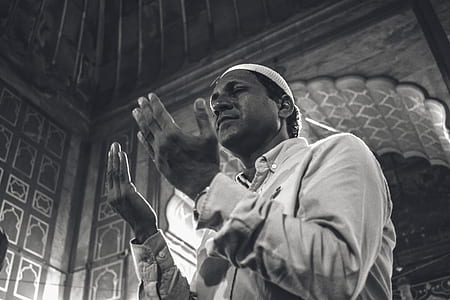 grayscale photography of man raising his hands thumbnail