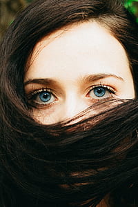 closeup photo of woman covering mouth using hair at daytime thumbnail