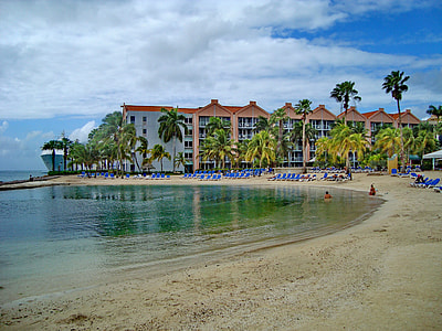 blue beach lounge near white and red buildings thumbnail