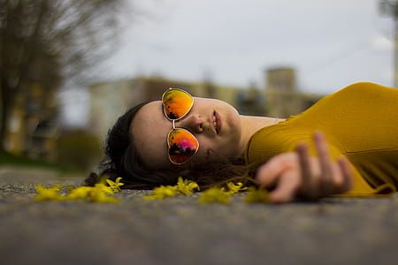 Closeup Photo of Woman Lying on Gray Pavement thumbnail