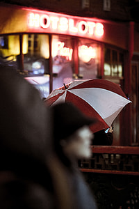 person under red and white umbrella near store thumbnail