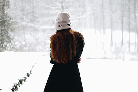 woman wearing black coat standing on snow covered ground thumbnail
