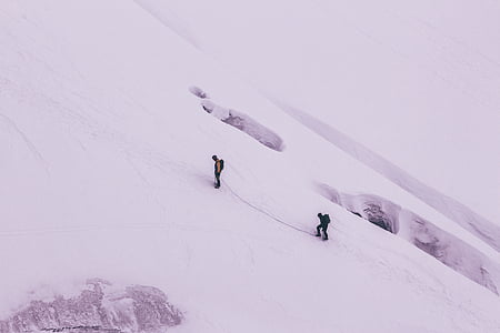 aerial photography of two person climbing on snowy mountain thumbnail