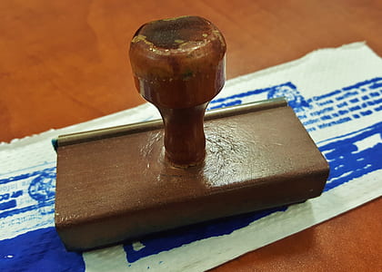 brown stamper placed on top of white sheet thumbnail