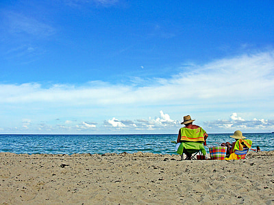 two person on white sand fronting body of water thumbnail