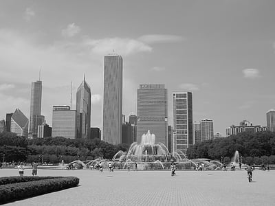 grayscale photography of people near fountain and buildings during daytime thumbnail