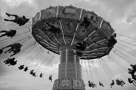 worm's eye view of people riding on amusement ride thumbnail