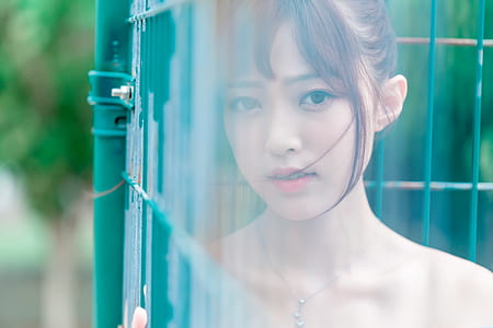 woman leaning on green metal fence thumbnail