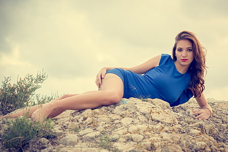 woman lying on rock wearing blue mini dress thumbnail