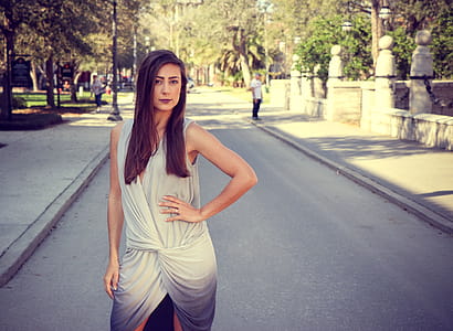 Woman Weairng White and Gray Sleeveless Dress Standing on Gray Road thumbnail
