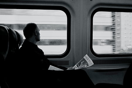person riding passenger vehicle while holding newspaper thumbnail