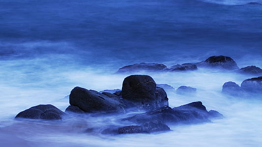 rock formation surrounded by body of water thumbnail