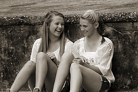 two girls sitting leaning at wall thumbnail