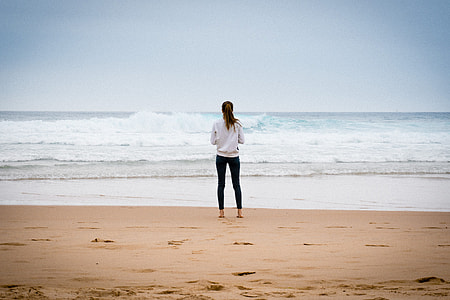 woman standing on sand near beach thumbnail