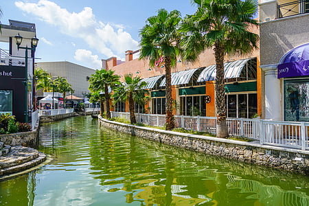 calm body of water beside brown concrete building thumbnail