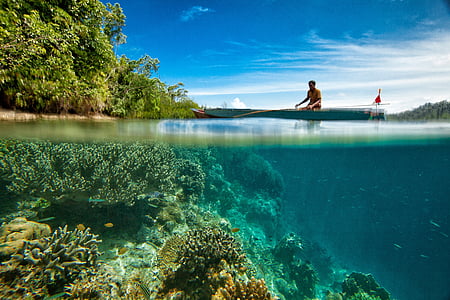 man riding on boat on body of water thumbnail
