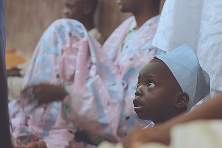 baby with white cap beside white textile thumbnail