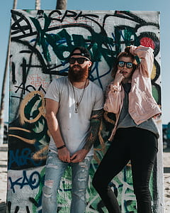 man and woman standing beside graffiti wall thumbnail