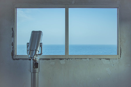 gray telescope beside clear glass window near body of water thumbnail